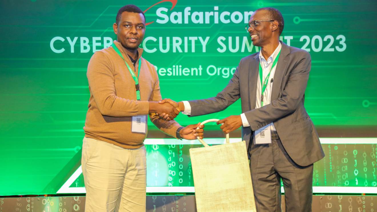 Martin Kioko from NetScout, one of the top sponsors at cyber security summit 2023, awards Alex Okoth, Account Relationship Manager, Safaricom PLC, for topping the trivia segment during Cyber Security Summit. PHOTO/SAFARICOM